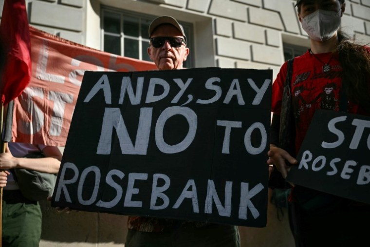 Un homme tient une pancarte contre le projet de champ pétrolier Rosebank, en mer du Nord; au large de l'Écosse, alors que des militants  écologistes manifestent à Londres, le 22 juillet 2026 ( AFP / JUSTIN TALLIS )