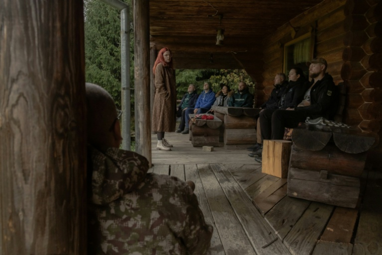 Des soignants militaires ukrainiens lors d'une séance de méditation dans un centre d'accueil, le 24 octobre 2025, dans les Carpates ( AFP / Roman PILIPEY )