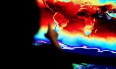 Un employé de la NASA devant une carte du monde affichant les informations transmises par satellites, lors d'une exposition immersive au siège de la NASA à Washington, le 21 juin 2023 ( AFP / Stefani REYNOLDS )