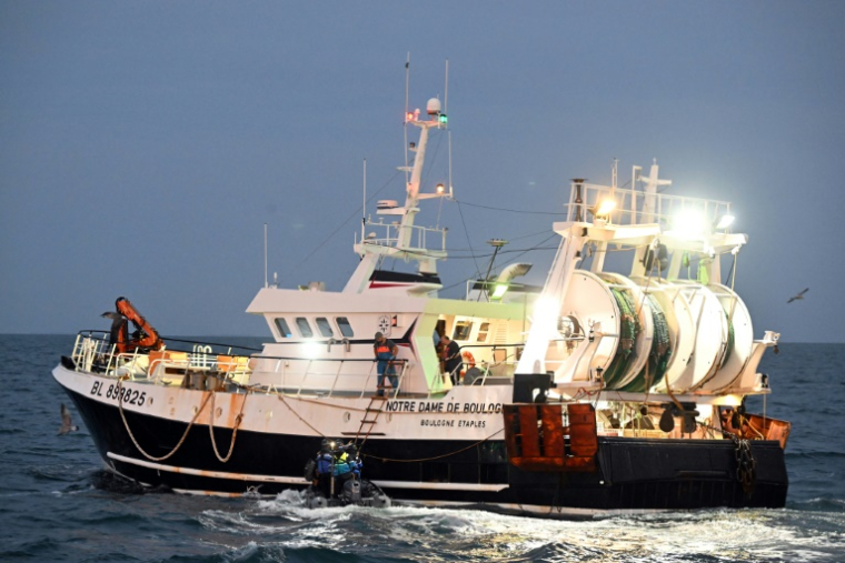 La gendarmerie maritime monte à bord du chalutier "Notre Dame de Boulogne", qui effectue du chalutage en tandem avec le  "Nicolas-Jeremy", pour une inspection lors d'une campagne de pêche à la sardine, au large de la Baie de Somme, le 8 septembre 2025 ( AFP / FRANCOIS NASCIMBENI )