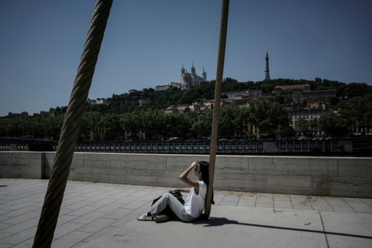 Une personne est assise sur les quais de la Saône, à Lyon, le 26 mai 2026, alors qu'une vague de chaleur frappe la France ( AFP / Jeff PACHOUD )