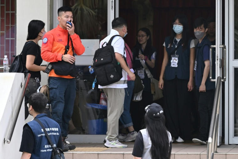 Des résidents du complexe résidentiel de Wang Fuk Court prêts à réintégrer leurs appartements, à Hong Kong, le 20 avril 2026 ( AFP / Peter PARKS )