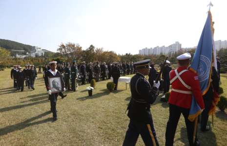 Cette photo fournie le 31 octobre 2026 par le ministère sud-coréen des Anciens combattants et des Affaires patriotiques, montrent des membres d'équipage de la frégate Vendémiaire de la Marine française portant le portrait et les restes de Serge Gabriel Archambeau, ancien combattant français de la guerre de Corée, lors d'une cérémonie d’inhumation au cimetière commémoratif des Nations unies à Busan ( South Korea’s Ministry of Patriots and Veterans Affairs / Handout )