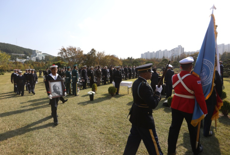 Cette photo fournie le 31 octobre 2026 par le ministère sud-coréen des Anciens combattants et des Affaires patriotiques, montrent des membres d'équipage de la frégate Vendémiaire de la Marine française portant le portrait et les restes de Serge Gabriel Archambeau, ancien combattant français de la guerre de Corée, lors d'une cérémonie d’inhumation au cimetière commémoratif des Nations unies à Busan ( South Korea’s Ministry of Patriots and Veterans Affairs / Handout )