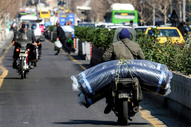 Une moto chargée de marchandises, le 21 février 2026 à Téhéran ( AFP / - )