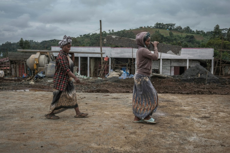 Deux jeunes filles transportent des matériaux de construction sur un chantier dans le centre de Beshasha (Ethiopie), la ville natale du Premier ministre éthiopien Abiy Ahmed, le 28 mai 2026 ( AFP / Marco Simoncelli )