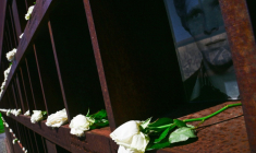 Des fleurs sont placées auprès de portraits de personnes mortes en tentant de fuir la RDA, lors d'une cérémonie commémorant le 65e anniversaire de l'édification du Mur de Berlin, à Berlin, le 13 août 2026 ( AFP / John MACDOUGALL )