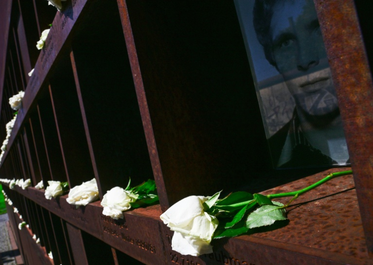 Des fleurs sont placées auprès de portraits de personnes mortes en tentant de fuir la RDA, lors d'une cérémonie commémorant le 65e anniversaire de l'édification du Mur de Berlin, à Berlin, le 13 août 2026 ( AFP / John MACDOUGALL )