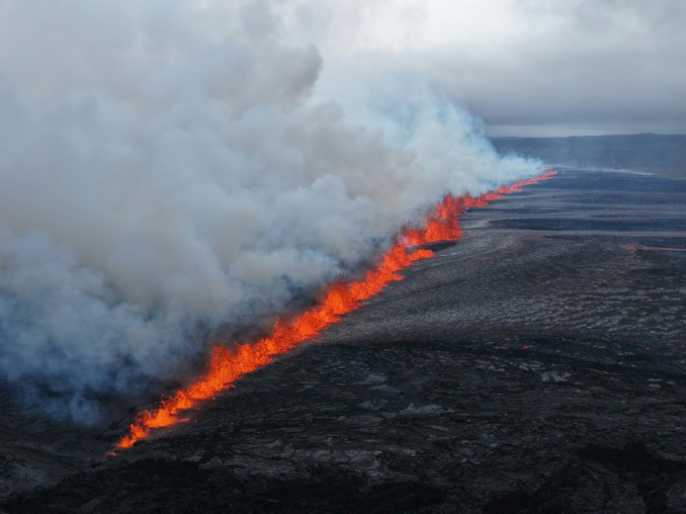 Photo diffusée le 16 juillet 2025 par les autorités islandaises montrant de la lave et de la fumée jaillissant d'un volcan près de Grindavik sur la péninsule islandaise de Reykjanes ( Département de la défense publique de la police d'État / Handout )