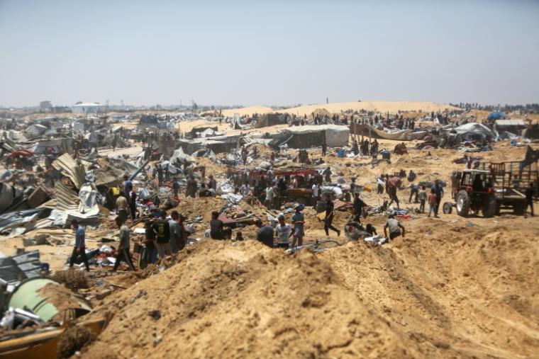 Des Palestiniens fouillent les débris d'un camp de déplacés près de Khan Younès, dans le sud de la bande de Gaza, au lendemain de ce que des témoins ont décrit comme une incursion de chars israéliens, le 11 juillet 2025 ( AFP / - )