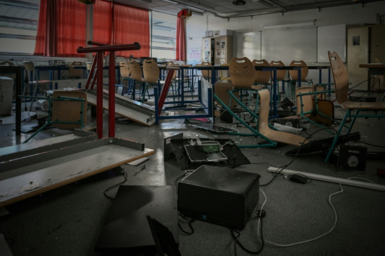 Des bureaux et des chaises renversés, des débris de verre et du matériel informatique endommagé dans une salle de classe du lycée "Les Iris" à Lormont, près de Bordeaux, le 8 octobre 2026, après que des jeunes ont saccagé une partie de l'établissement ( AFP / Philippe LOPEZ )