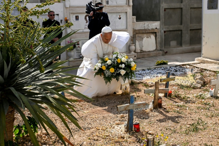 Pope Leo XIV lays a wreath of flower on the unmarked graves of shipwreck victims at the cemetery during a one day visit to Lampedusa island, south of Sicily, on July 4, 2026. ( POOL / Ciro FUSCO )