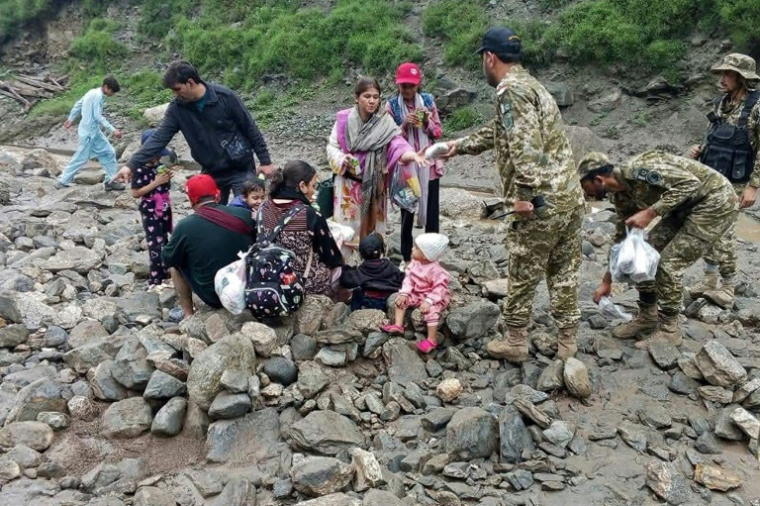 Photo publiée le 22 juillet 2025 par le gouvernement du Gilgit-Baltistan de soldats de l'armée pakistanaise aidant des personnes à évacuer la zone touchée par un glissement de terrain à Babusar, au Pakistan ( Gouvernement du Gilgit-Baltistan / Handout )