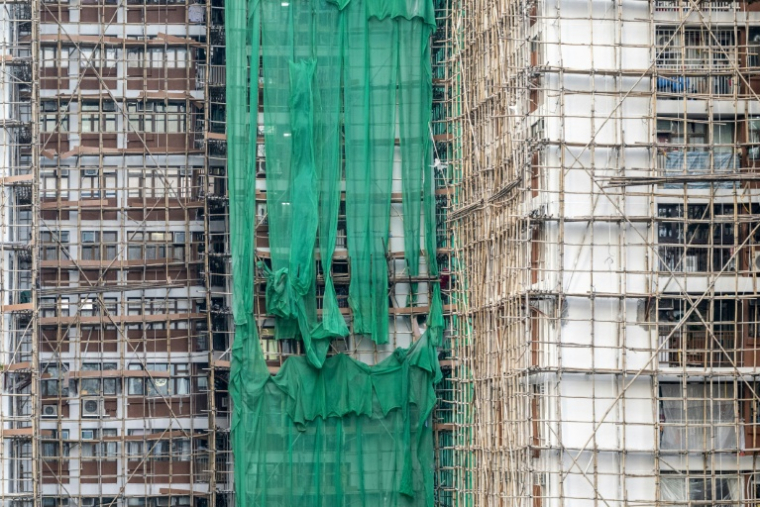 Des filets de protection en cours d'enlèvement sur un immeuble en chantier à Hong Kong, en Chine, le 4 décembre 2025 ( AFP / Philip FONG )