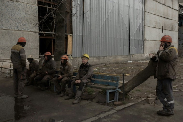 Des employés font une pause durant les réparations d'une centrale énergétique DTEK endommagée par les attaques aériennes russes. ( AFP / Roman PILIPEY )