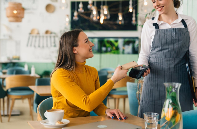 (Crédits photo : Adobe Stock - Cliente réglant sa note de restaurant via paiement mobile