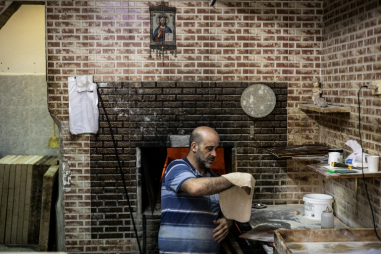 Un homme prépare de la pâte à pain dans une boulangerie de Zababde, en Cisjordanie occupée, à l'approche de Pâques le 10 avril 2025 ( AFP / John WESSELS )