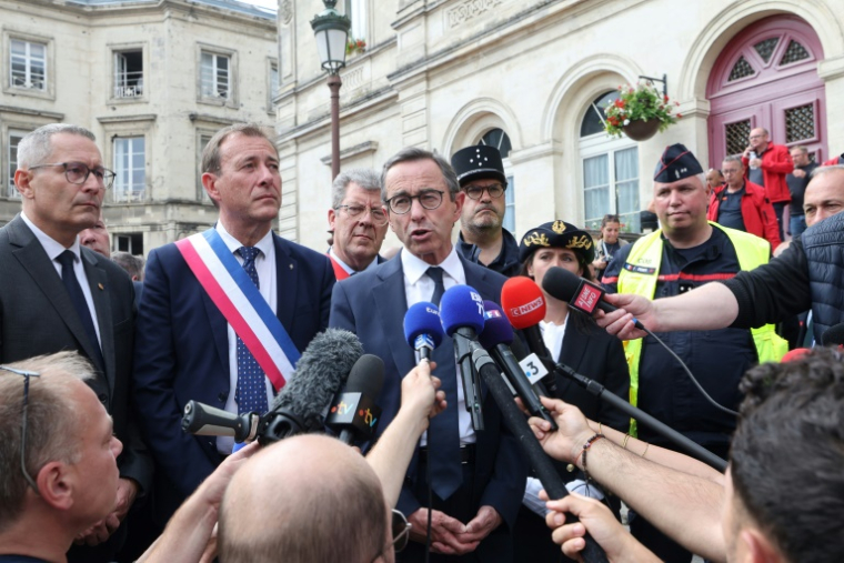 Le ministre de l'Intérieur Bruno Retailleau (c) s'exprime devant la presse aux côtés du maire de Laon Eric Delhaye (2e g), le 10 juin 2025 à Laon ( AFP / Francois LO PRESTI )