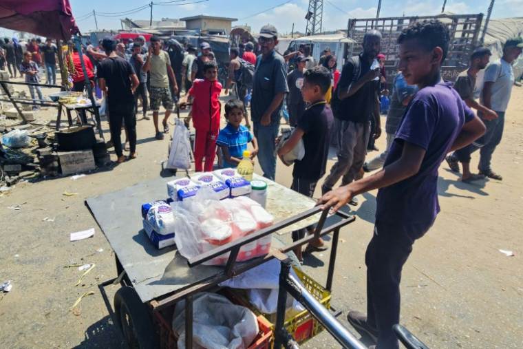 Des Palestiniens regardent des denrées alimentaires sur un étal dans la zone de Mawassi, à Rafah, dans le sud de la bande de Gaza, le 20 juillet 2025 ( AFP / - )