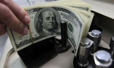 Un employé de banque compte des billets de cent dollars américains à la Kasikornbank à Bangkok