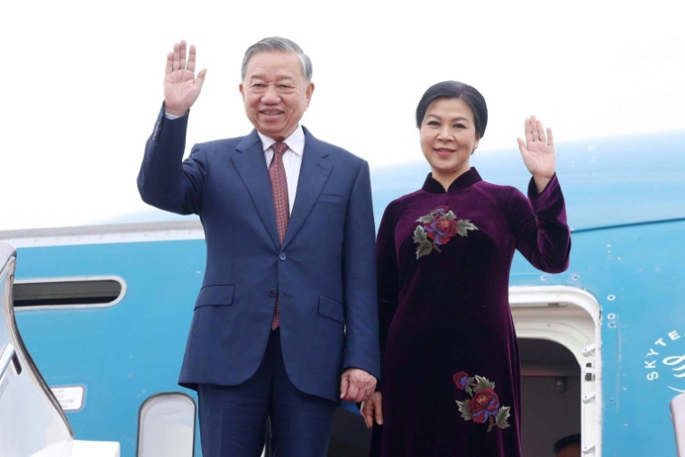 Photo prise et diffusée par l'Agence de presse vietnamienne (VNA) le 14 avril 2026, montrant le secrétaire général du Parti communiste vietnamien, To Lam, et son épouse, Ngo Phuong Ly, à leur arrivée à l'aéroport international de Pékin ( Vietnam News Agency / STR )