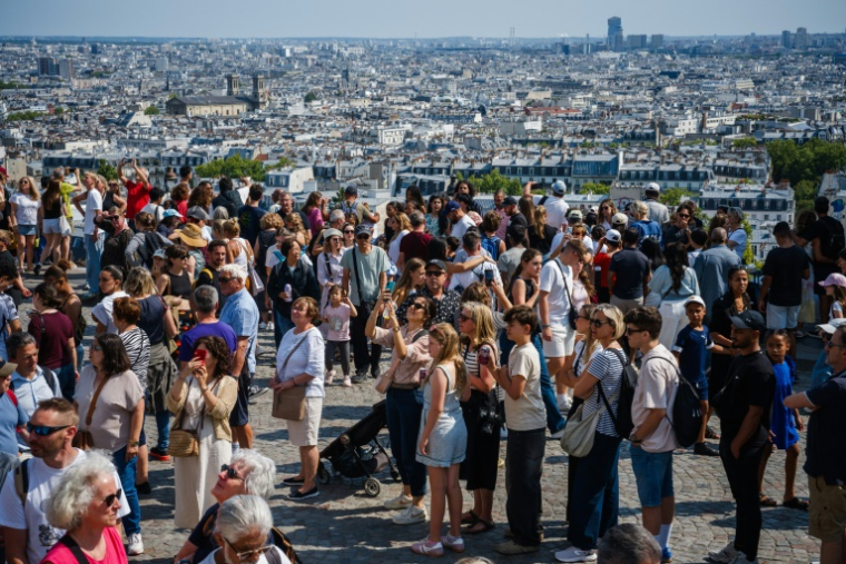 Des touristes au pied de la basilique du Sacré-Coeur à Montmartre, le 5 août 2025 à Paris ( AFP / Dimitar DILKOFF )