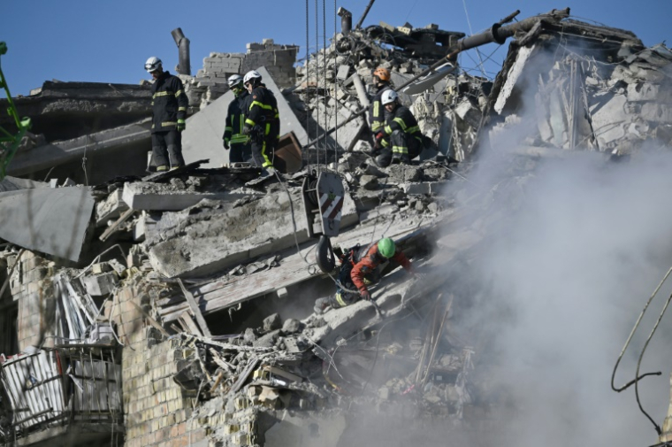 Des sauveteurs ukrainiens fouillent les décombres d'un immeuble résidentiel gravement endommagé lors d'une attaque massive de drones et de missiles russes sur Kiev, le 28 août 2025 ( AFP / Genya SAVILOV )