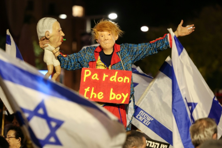 Un manifestant costumé comme Donald Trump tient une marionnette de Benjamin Netanyahu lors d'une manifestation en faveur de l'établissement d'une commission d'enquête nationale sur le 7-Octobre le 15 Novembre 2025 à Tel-Aviv. ( AFP / Jack GUEZ )