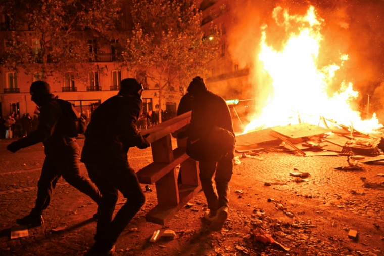 Des protestataires alimentent un feu boulevard Haussmann lors d'une manifestation contre la vie chère à Paris, le 17 octobre 2026  ( AFP / Guillaume Saligot )
