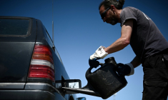 Un membre de "Roule ma frite", une association spécialisée dans la récupération et le recyclage des huiles de friture usagées en circuit court, remplit le réservoir d'une voiture diesel avec de l'huile usagée recyclée, le 10 mai 2022 à Bourcefranc-le-Chapus, en Charente-Maritime ( AFP / Philippe LOPEZ )