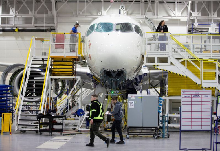 Des employés travaillent sur un Airbus A220-300 à l'usine de Mirabel