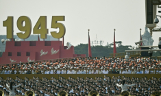 Des personnes chantent derrière une fanfare militaire avant un défilé militaire marquant le 80e anniversaire de la victoire sur le Japon et la fin de la Seconde Guerre mondiale, sur la place Tiananmen de Pékin le 3 septembre 2025 ( AFP / Pedro Pardo )