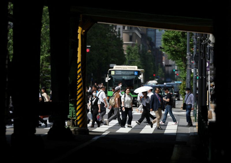 Des passants marchent sur un passage piéton à Tokyo