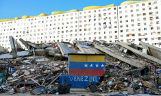 Un drapeau vénézuélien est peint sur un mur endommagé, au milieu des décombres d'un immeuble effondré à la suite des séismes qui ont frappé Caraballeda, dans l'Etat de La Guaira, au Venezuela, le 26 juin 2026 ( AFP / Maryorin Mendez )