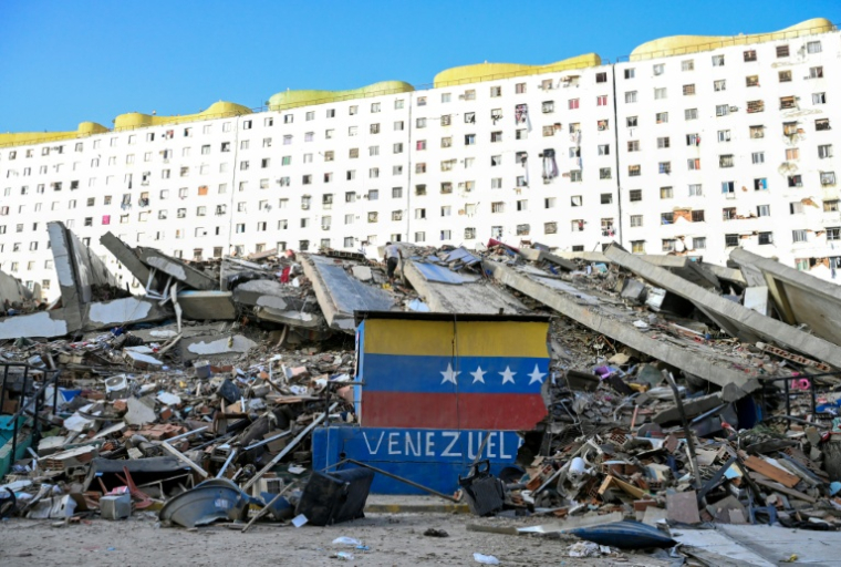 Un drapeau vénézuélien est peint sur un mur endommagé, au milieu des décombres d'un immeuble effondré à la suite des séismes qui ont frappé Caraballeda, dans l'Etat de La Guaira, au Venezuela, le 26 juin 2026 ( AFP / Maryorin Mendez )