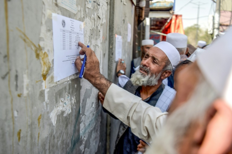 Un retraité vérifie une liste devant un bâtiment gouvernemental à Kabou, le 25 août 2025 en Afghanistan ( AFP / Bais Yusufi )