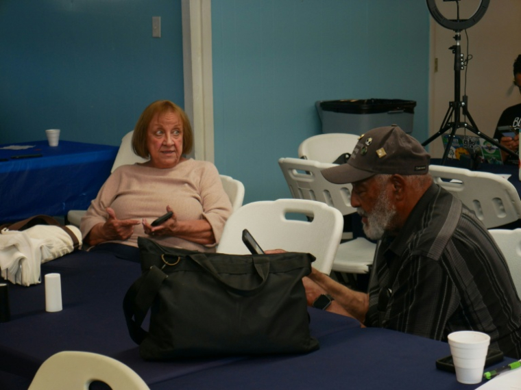 Debbie Wills, coordinatrice du Black Lung Program au Valley Health System, et Gary Hairston (d), président d'une association nationale de défense des mineurs malades,  lors d'une réunion, le 13 août 2026 à Cabin Creek, en Virginie-Occidentale ( AFP / Pierre HARDY )