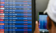 Un passager prend une photo d'un tableau d'affichage des vols annulés vers les destinations du Moyen-Orient à l'aéroport international de Bombay le 1er mars 2026 en Inde ( AFP / Punit PARANJPE )