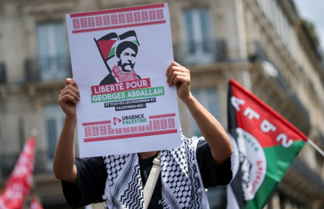 Une personne tenant une pancarte sur laquelle on peut lire "Liberté pour Georges Abdallah et pour tous les prisonniers palestiniens" à une manifestation en soutien aux Palestiniens de Gaza