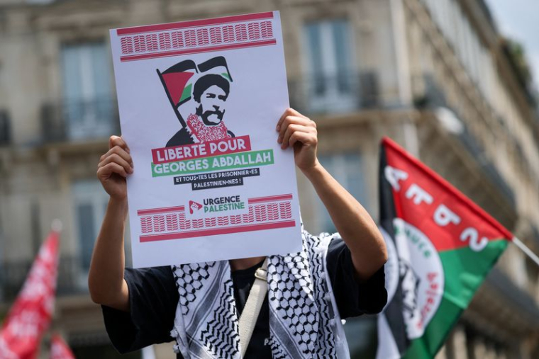 Une personne tenant une pancarte sur laquelle on peut lire "Liberté pour Georges Abdallah et pour tous les prisonniers palestiniens" à une manifestation en soutien aux Palestiniens de Gaza