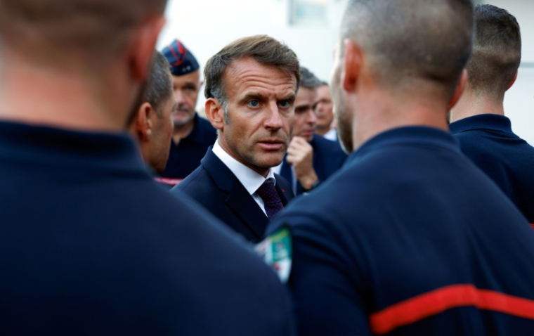 Emmanuel Macron salue les pompiers mobilisés pour lutter contre les incendies, à l'issue d'une visite au centre opérationnel départemental d'incendie et de secours (Codis) de Bordeaux, en Gironde, le 27 juillet 2026 ( POOL / Kenzo TRIBOUILLARD )