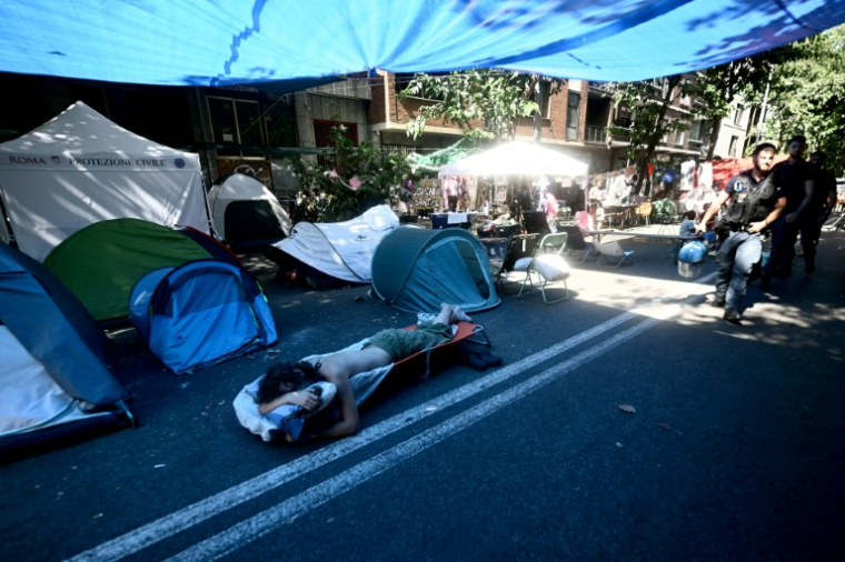Des personnes récemment expulsées d'un centre social à Rome campent à l'extérieur du centre, le 11 août 2026 ( AFP / Filippo MONTEFORTE )