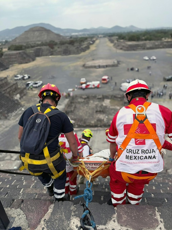 Cette photo diffusée par la Croix-Rouge mexicaine montre des experts médico-légaux et des membres de la Croix-Rouge transportant un corps sur la pyramide de la Lune, sur le site archéologique de Teotihuacan, dans l'Etat de Mexico, le 20 avril 2026 ( MEXICAN RED CROSS / Handout )