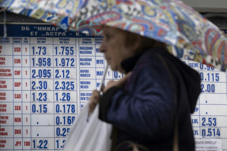 Une femme passe devant un bureau de change à Sofia, le 30 mai 2025 en Bulgarie ( AFP / Nikolay DOYCHINOV )