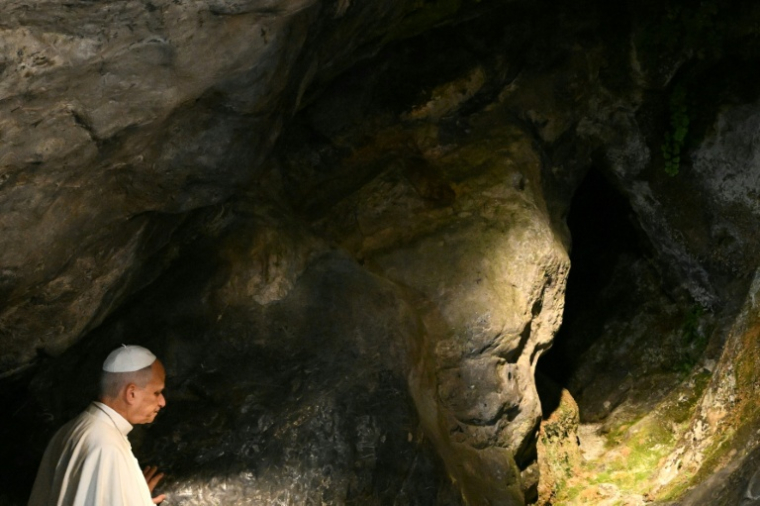 Le pape Léon XIV touche la roche de la grotte de Massabielle à Lourdes, lors d'une prière, le 26 septembre 2026 ( AFP / Lionel BONAVENTURE )