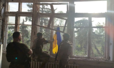 Photo des soldats ukrainiens qui placent un drapeau ukrainien sur un bâtiment, lors d'une opération qui prétend libérer le premier village au milieu d'une contre-offensive à l'est de l'Ukraine