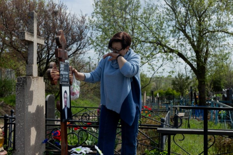 Tetiana Zaïtseva devant la tombe de son fils Artem, à Kryvyï Rig en Ukraine, le 20 avril 2026 ( AFP / Tetiana DZHAFAROVA )