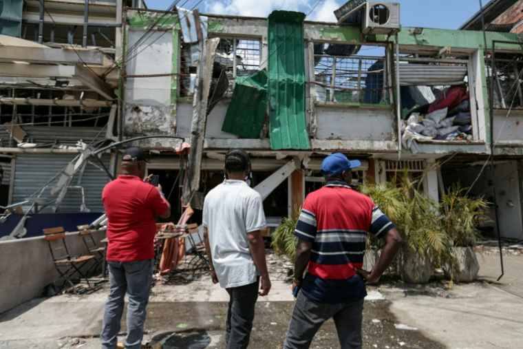 Des personnes regardent un bâtiment endommagé sur le site d'une explosion à la bombe survenue la veille à Cali, en Colombie, le 22 août 2025 ( AFP / Iusef Samir Rojas )