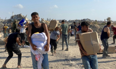 Des Palestiniens sur la défensive alors que des tirs se font entendre lors d'une distribution de nourriture par le groupe GHF à Rafah, dans le sud de la bande de Gaza, le 27 mai 2025 ( AFP / - )