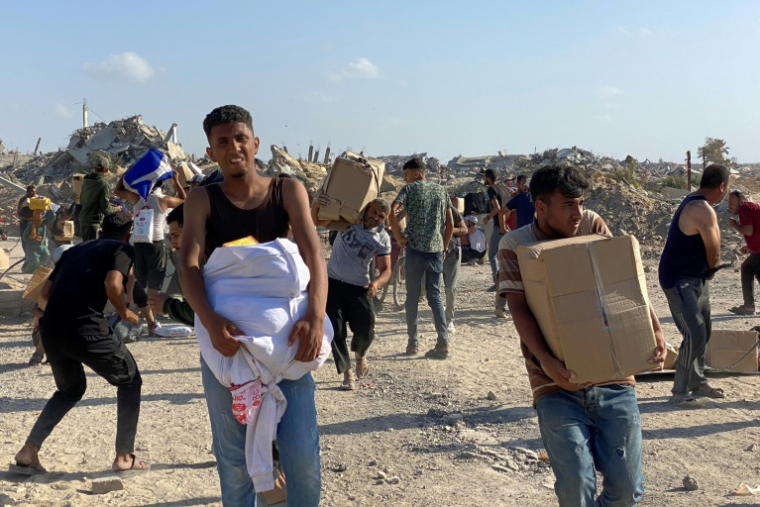 Des Palestiniens sur la défensive alors que des tirs se font entendre lors d'une distribution de nourriture par le groupe GHF à Rafah, dans le sud de la bande de Gaza, le 27 mai 2025 ( AFP / - )